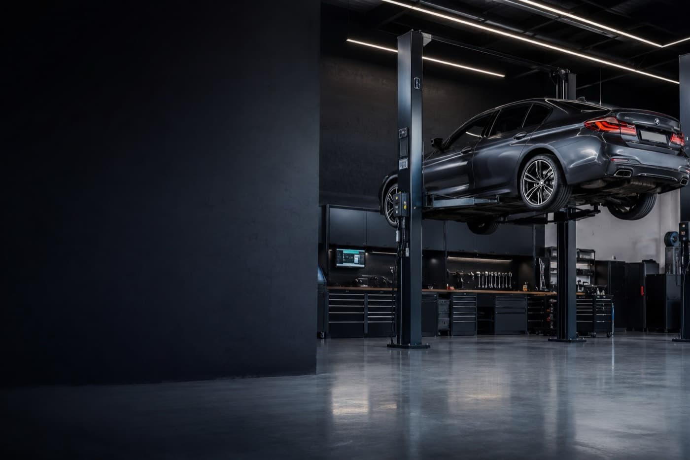 A Nova Tyres workshop bay with a car on the hoist